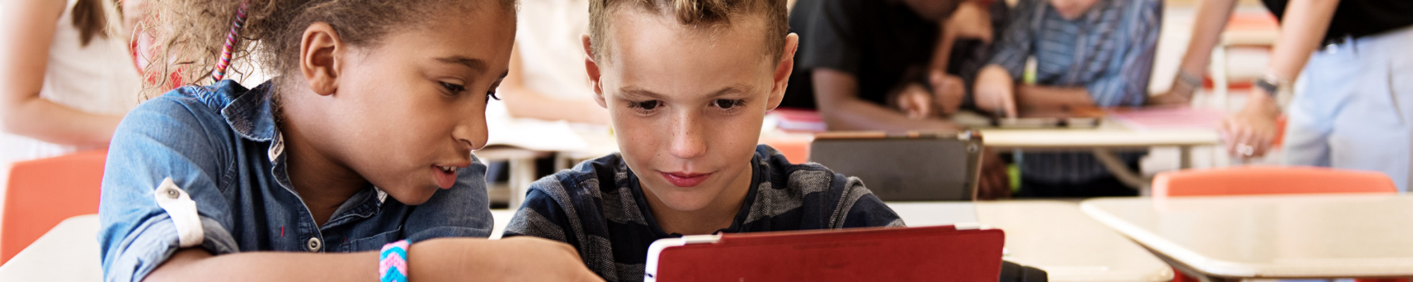 two students in class working on an ipad