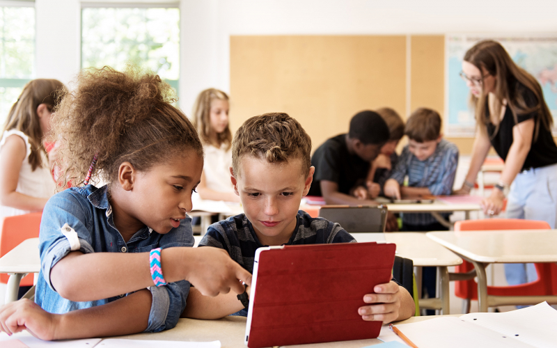 two students in class working on an ipad